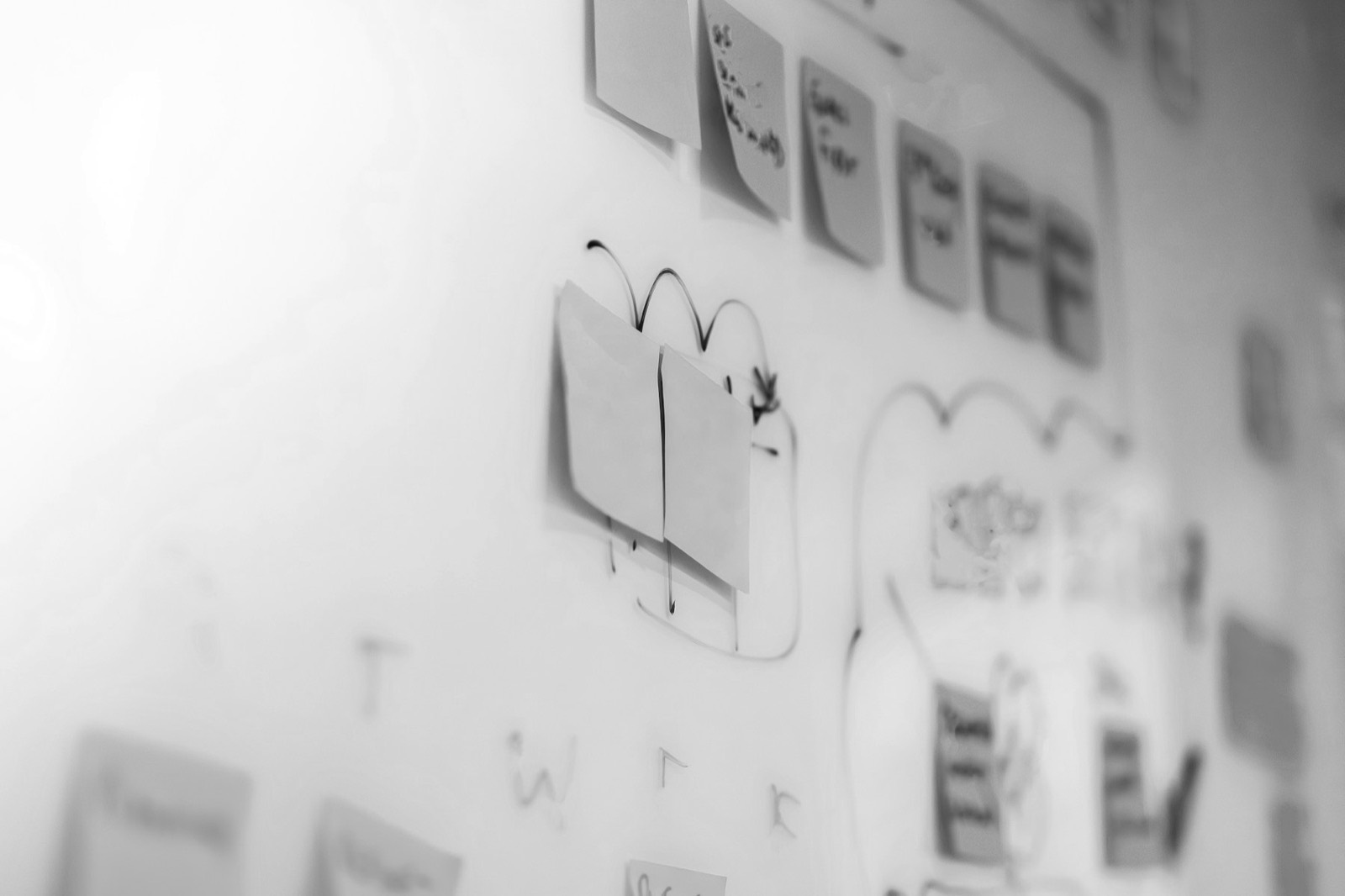 Close-up of a physical whiteboard covered in sticky notes and marker strokes